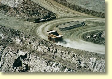 Haul Trucks at the bottom of the Kalgoorlie- Boulder Super Pit. Gold recovery rates are in the order of grammes per ton.