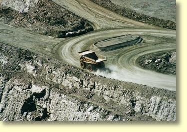 Haul Trucks at the bottom of the Kalgoorlie- Boulder Super Pit.  Gold recovery rates are in the order of grammes per ton.